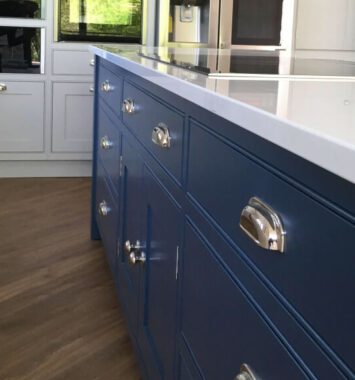 Dark blue bespoke kitchen with silver handles and white quarts